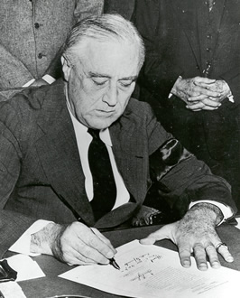 Photograph of FDR signing the Declaration 			  of War on Japan.
